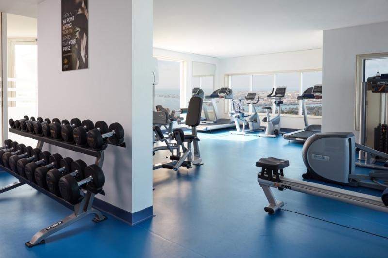 Hotel Jannah Burj Al Sarab Abu Dhabi Esterno foto The photo shows a modern gym or fitness area. On one side, there is a rack of dumbbells arranged in order of weight. In the background, several pieces of gym equipment are visible, including treadmills and stationary bikes. The space features large w